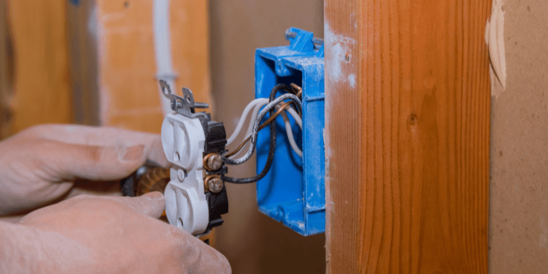 Electrician installing electrical outlet